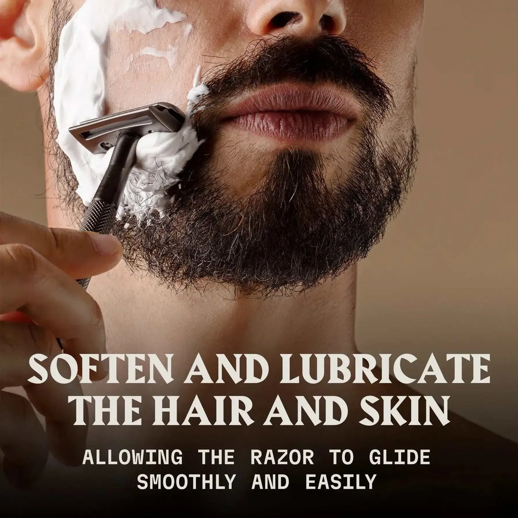 Man applying shaving cream with razor, promoting Striking Viking Pre-Shave Oil for smooth and effortless shave with sandalwood scent.