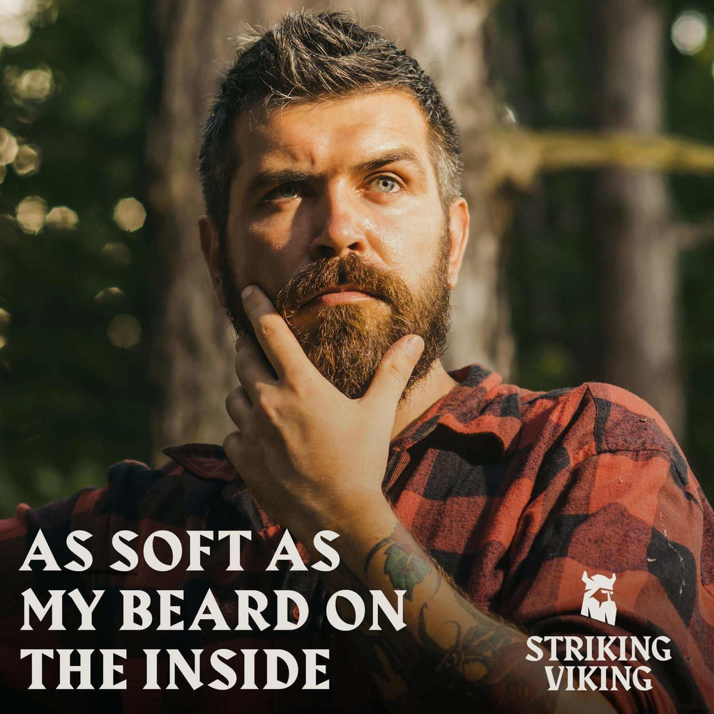 Man stroking beard outdoors with text "As Soft As My Beard On The Inside" promoting Striking Viking Beard Oil Unscented.